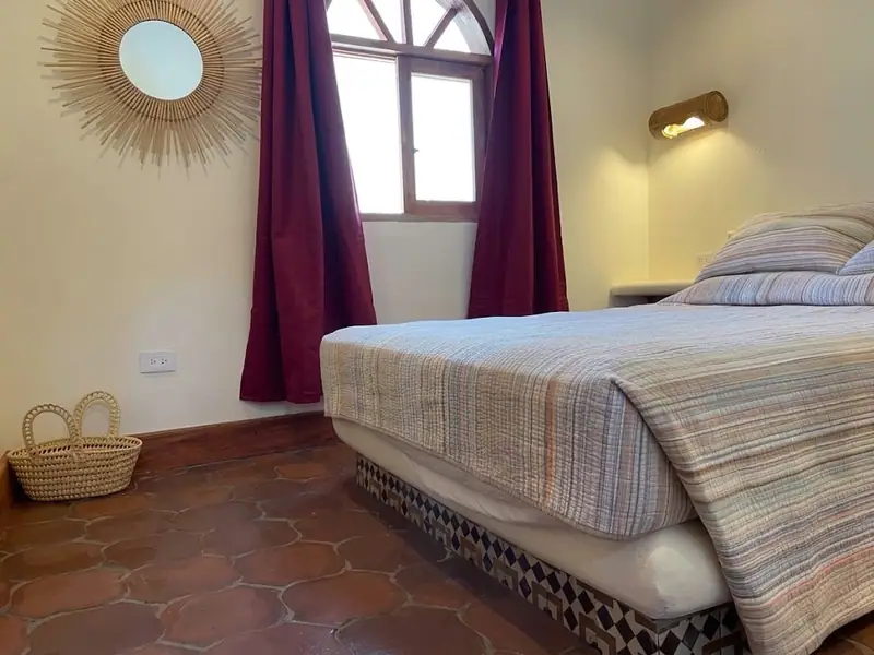 Habitación con cama doble y ventana en arco