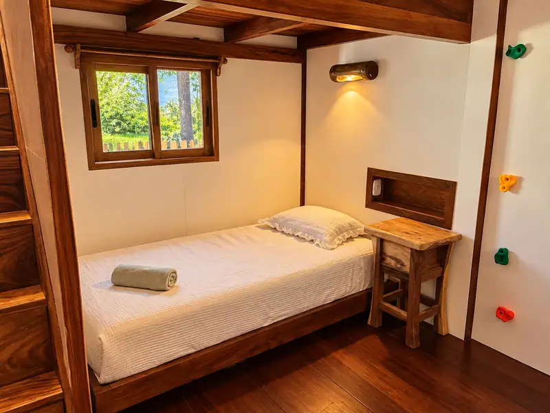 A single bed with climbing holds in the Hacienda