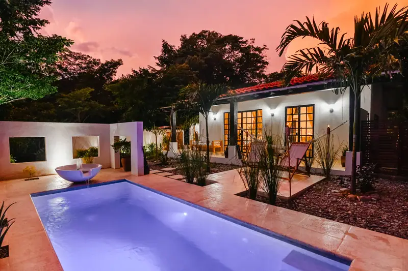 Villa Mariposa al atardecer, con la piscina iluminada